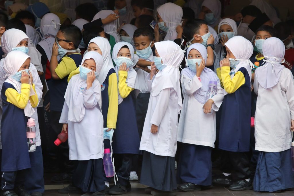 Students cover their faces with masks at a school as haze shrouds Kuala Lumpur, Malaysia. Photo: Reuters